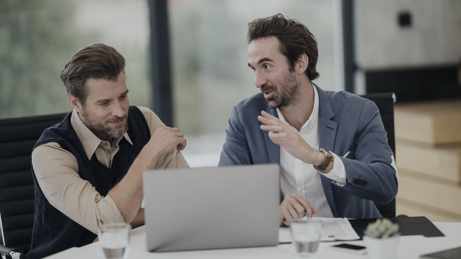Two team members reviewing OTA performance together on a laptop